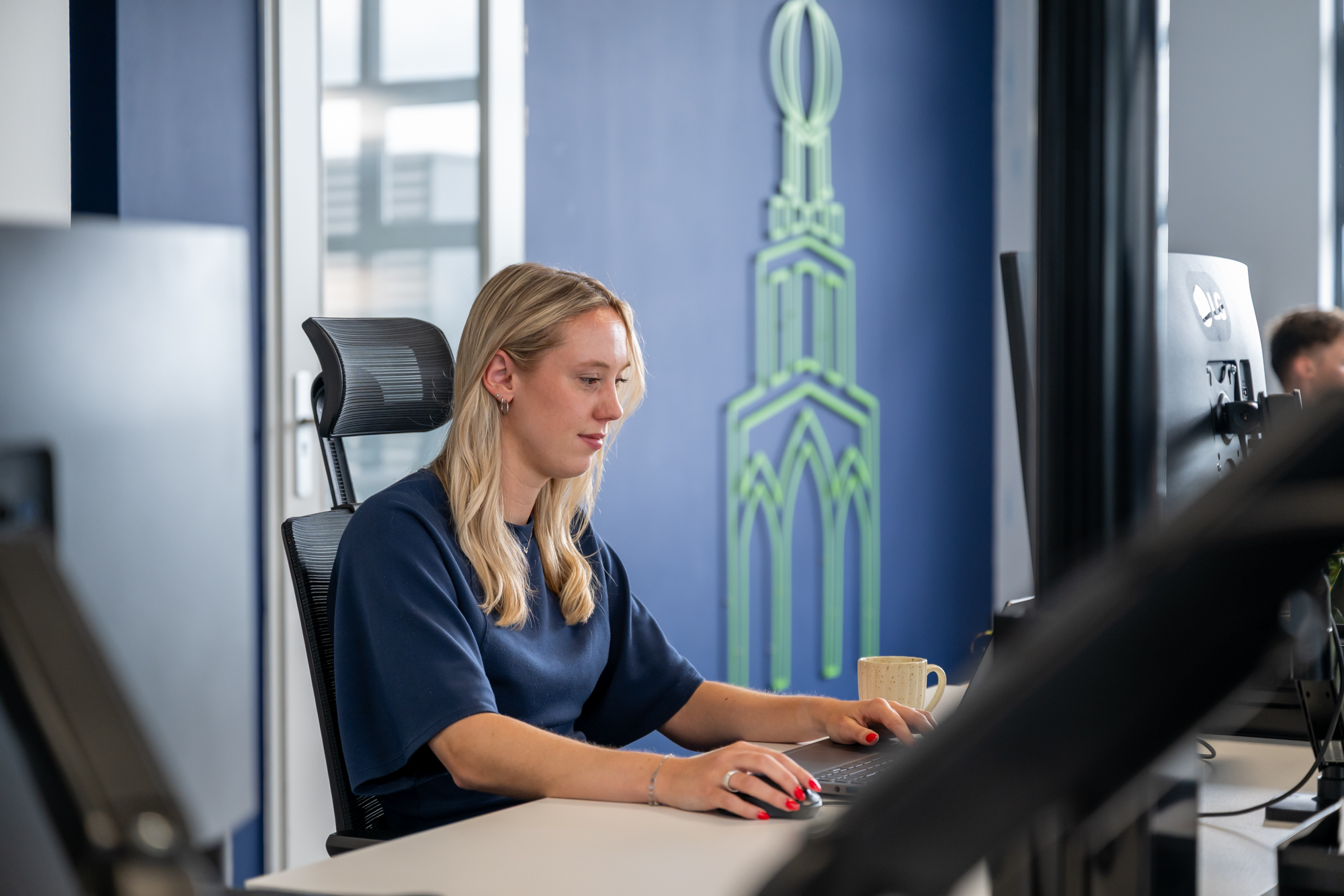 Sanne werkt op haar laptop bij 050 Marketing