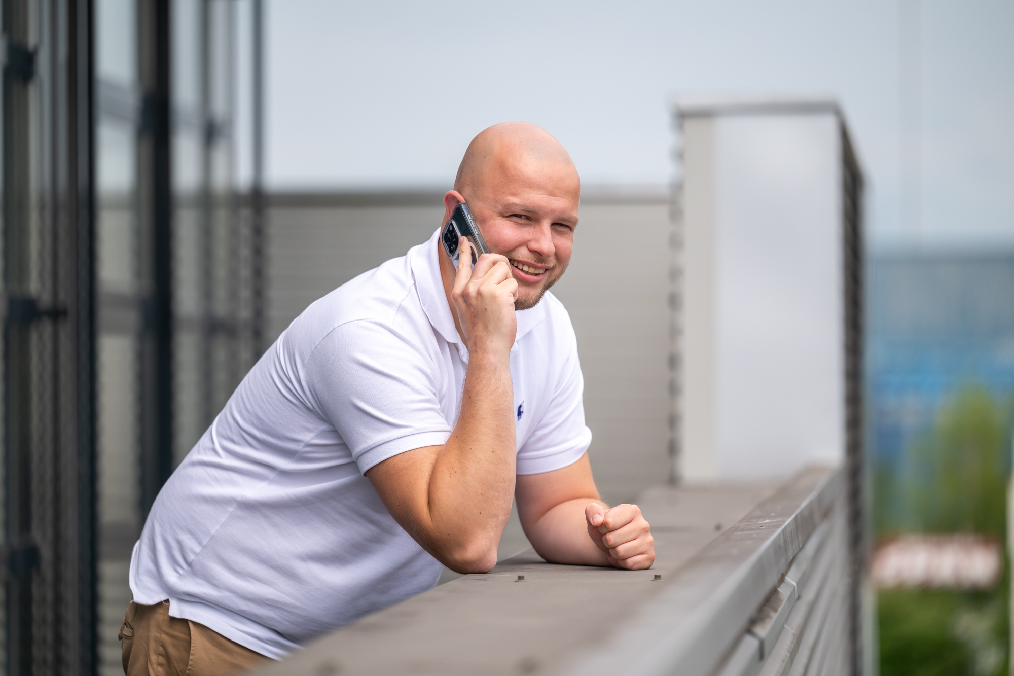 Tom belt lachend op het dakterras van het kantoor